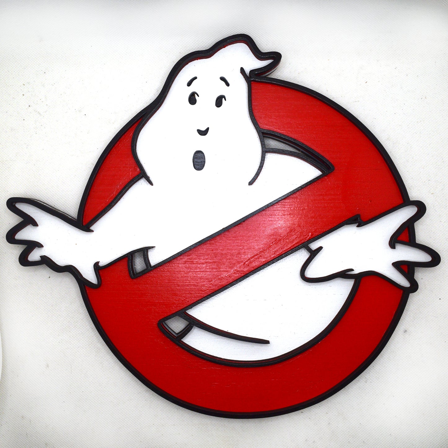Ghostbusters logo with a white ghost on a red circle against a white background