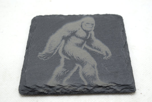 Slate coaster with engraved image of a bigfoot on a white background