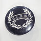 Round button badge with 'A.C.A.B.' text and laurel wreath on a black background