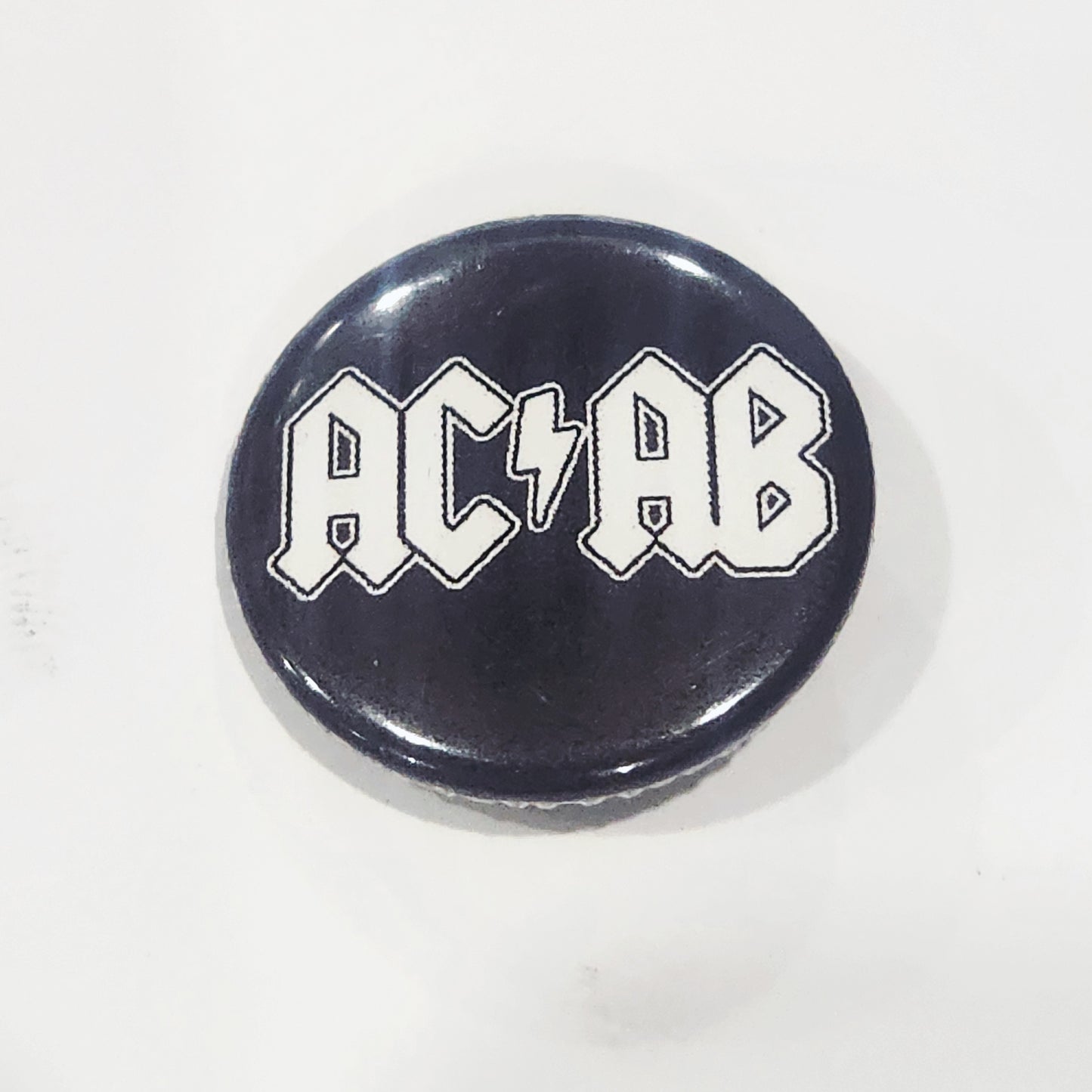 Button badge with 'ACAB' text on a black background