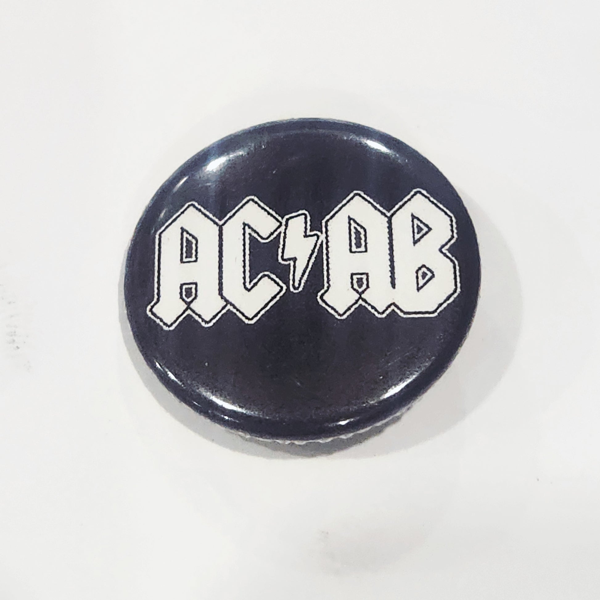 Button badge with 'ACAB' text on a black background