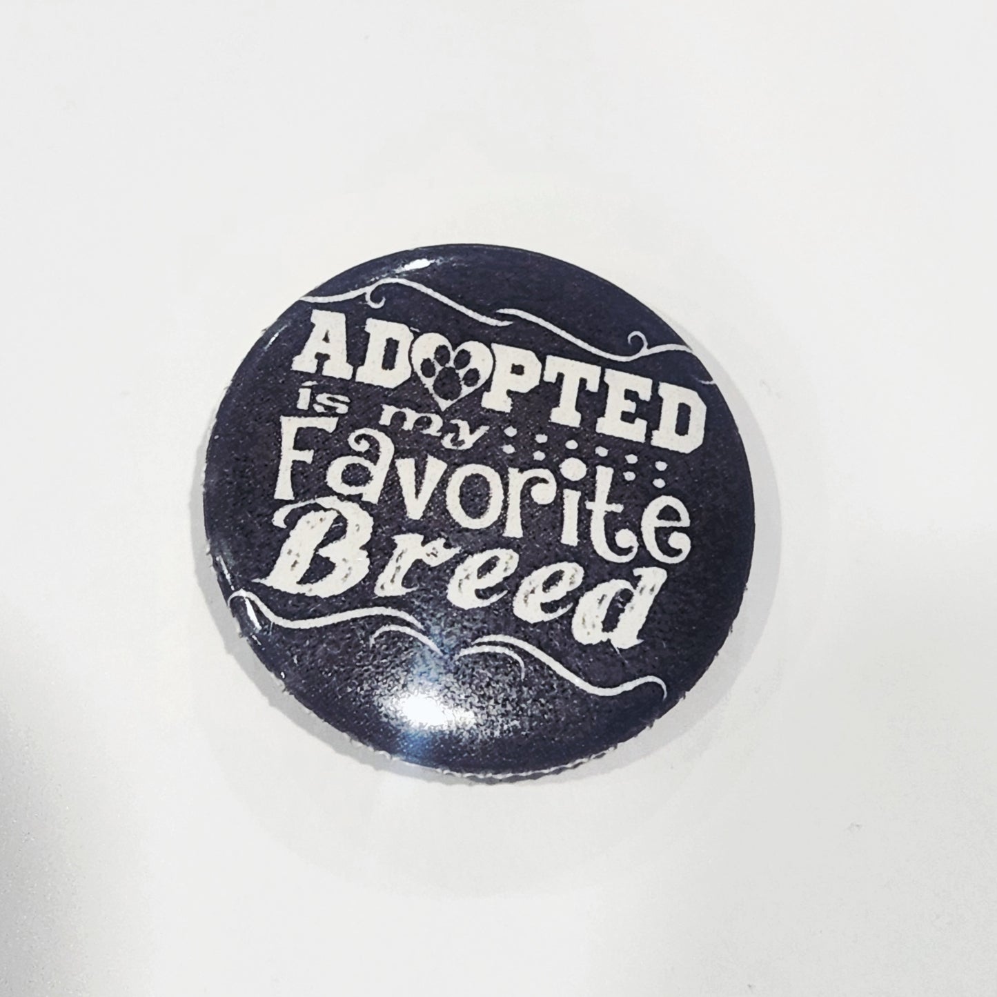 Button badge with 'Adopted is my Favorite Breed' text on a black background