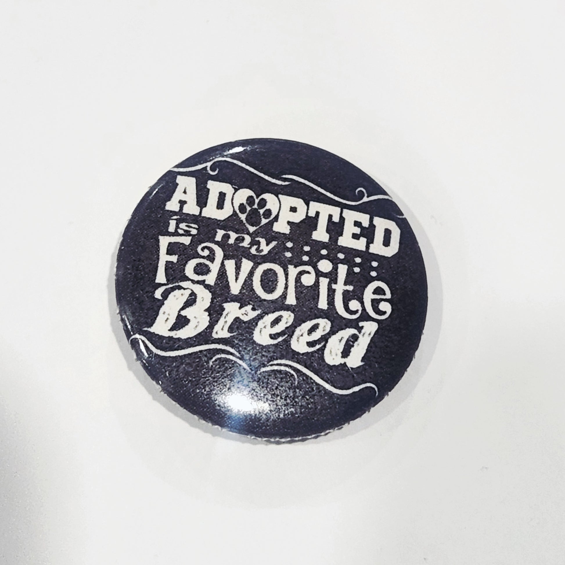 Button badge with 'Adopted is my Favorite Breed' text on a black background