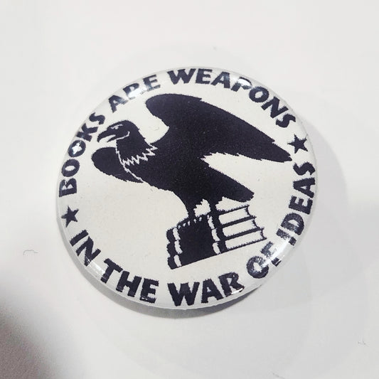Button badge with an eagle holding books and text 'Books are weapons in the war of ideas' on a white background