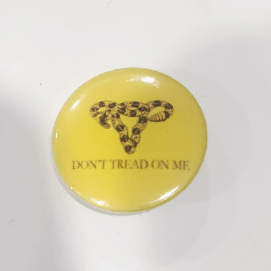 Round yellow button with a snake design and 'Don't Tread on Me' text on a white background