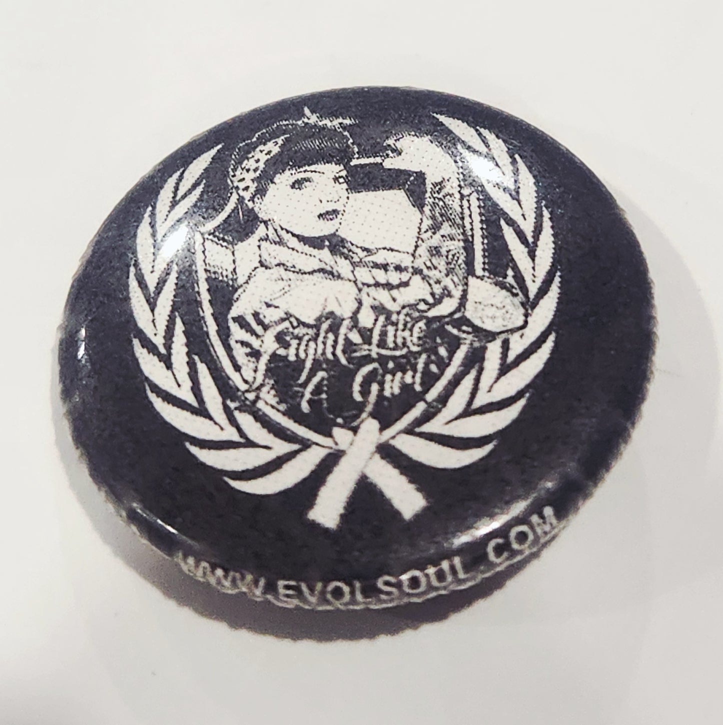 Button badge with 'Fight Like Girl' design and laurel wreath on a white background