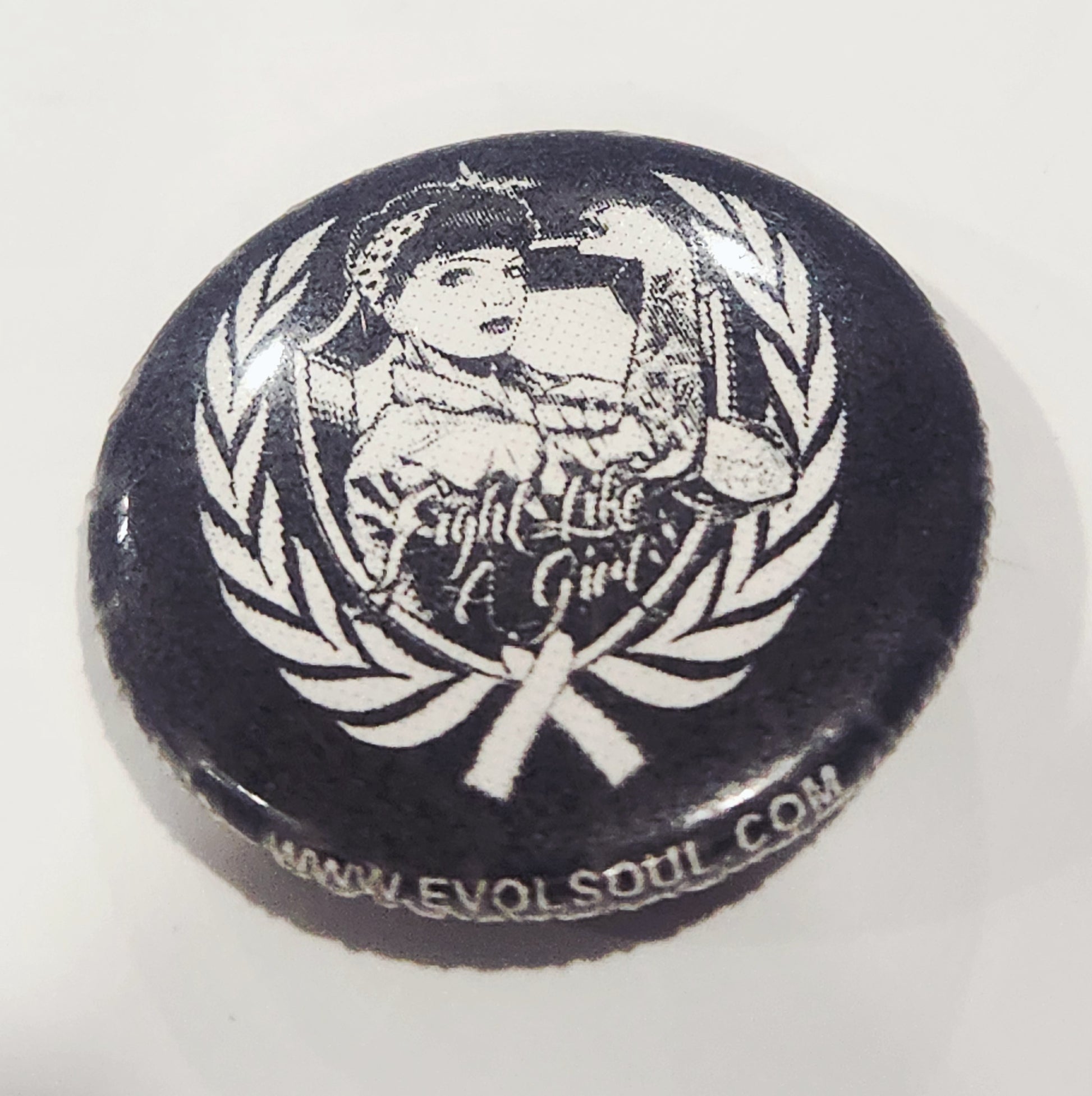 Button badge with 'Fight Like Girl' design and laurel wreath on a white background