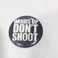 Button badge with 'HANDS UP DON'T SHOOT' text
