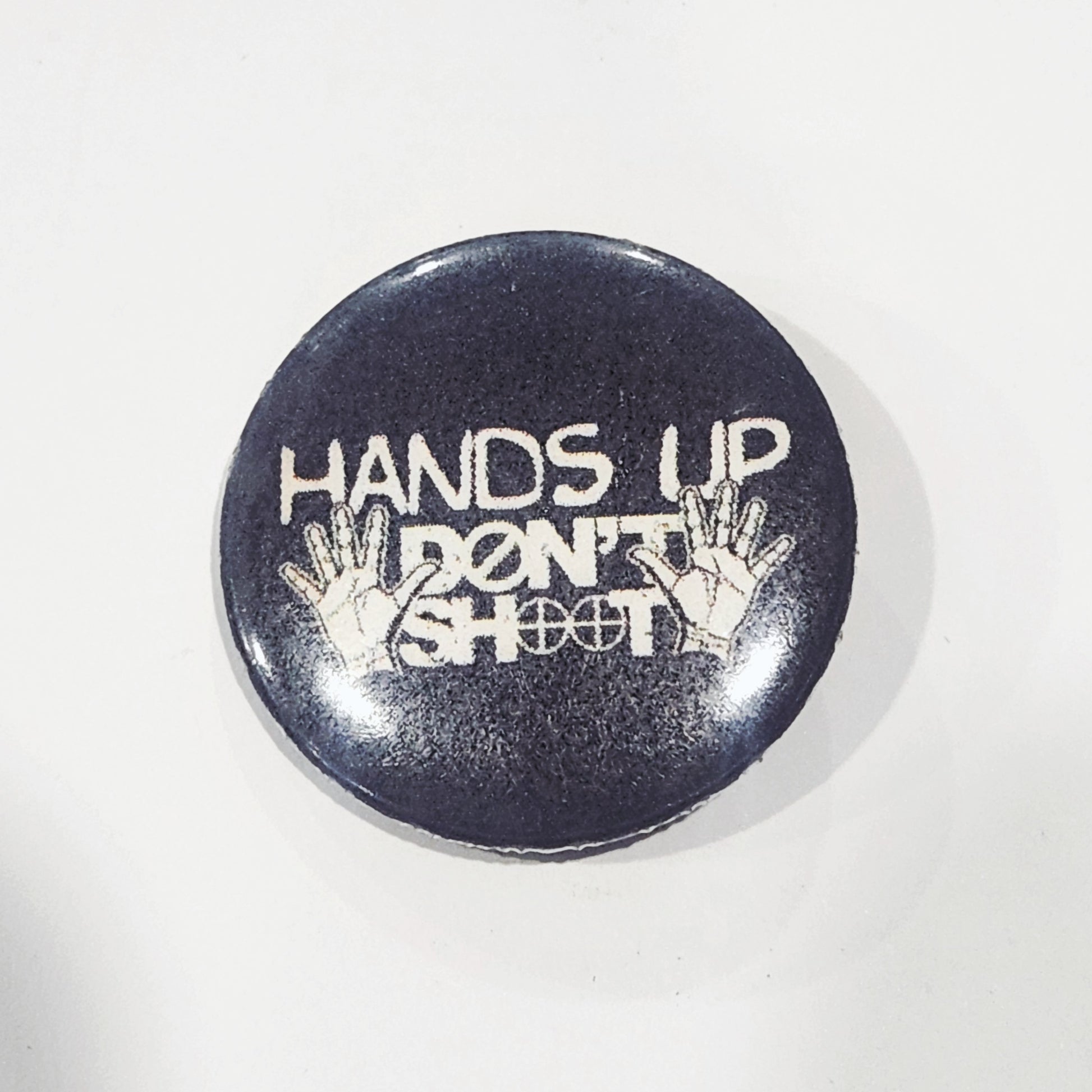 Button badge with 'Hands Up Don't Shoot' text 