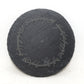 Round slate coaster with engraved  quote on a white background