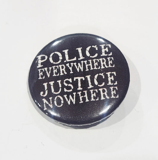 Button badge with 'POLICE EVERYWHERE JUSTICE NOWHERE' text on a black background