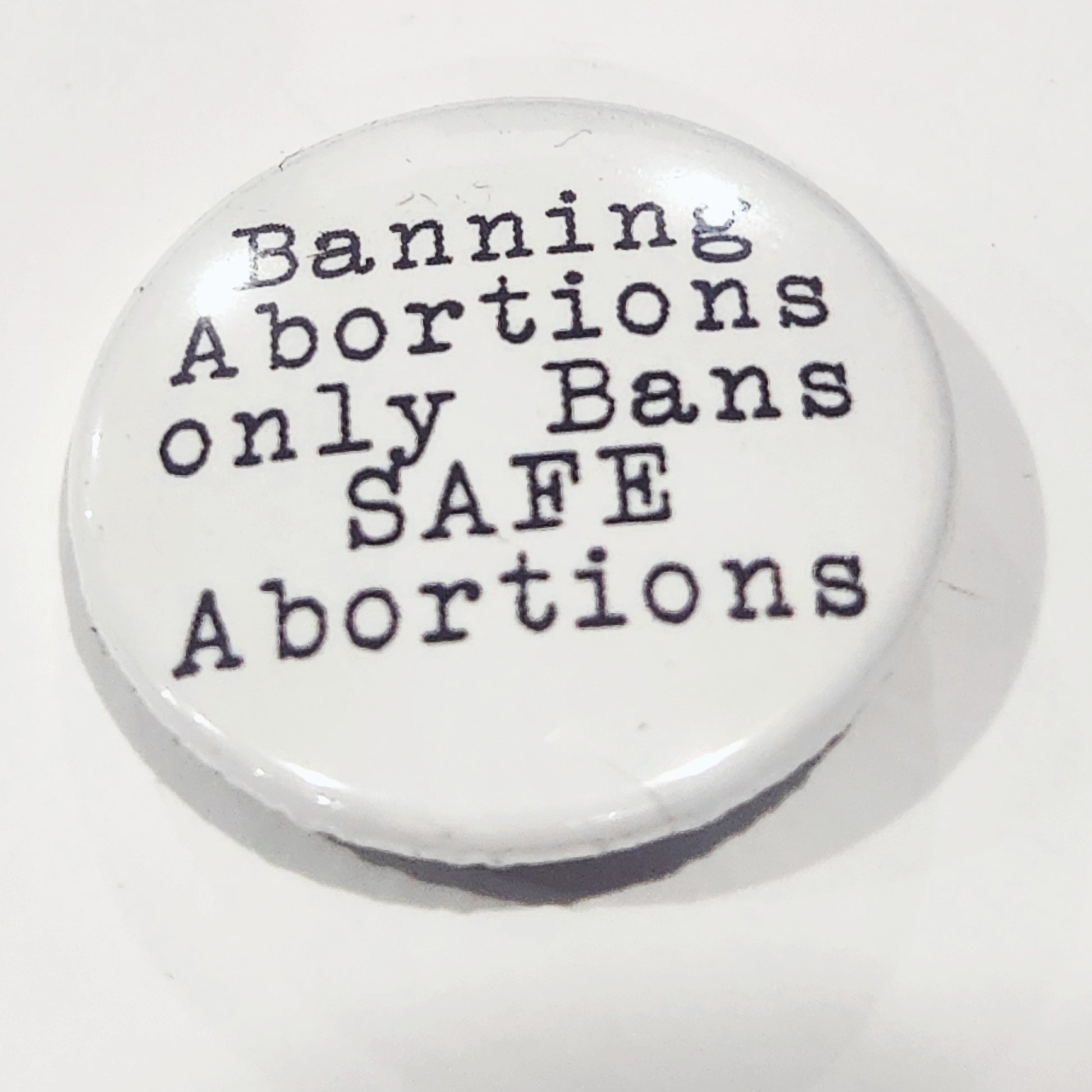 Button with text 'Banning Abortions only Bans SAFE Abortions' on a white background